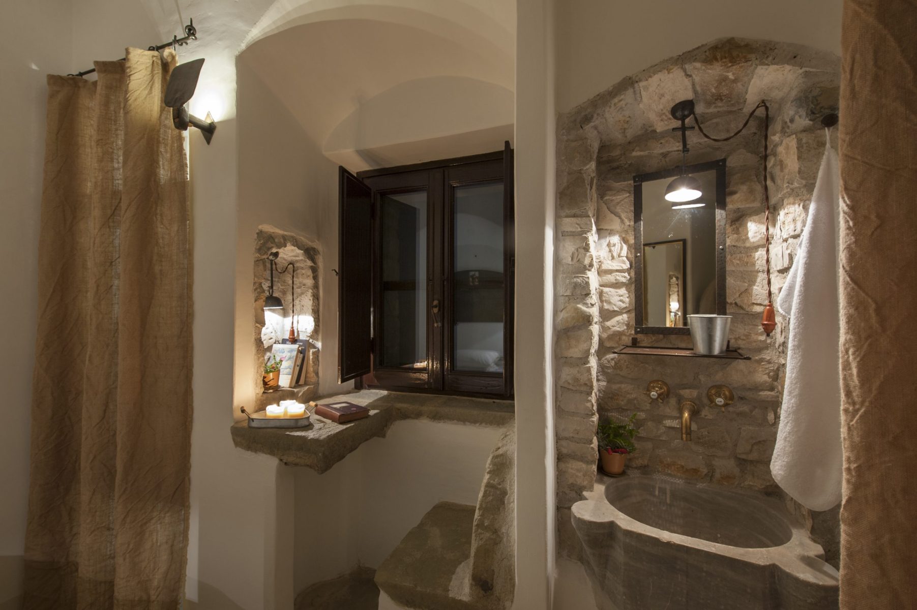 Bagno di una celluzza con lavabo in pietra e finestra sulla valle