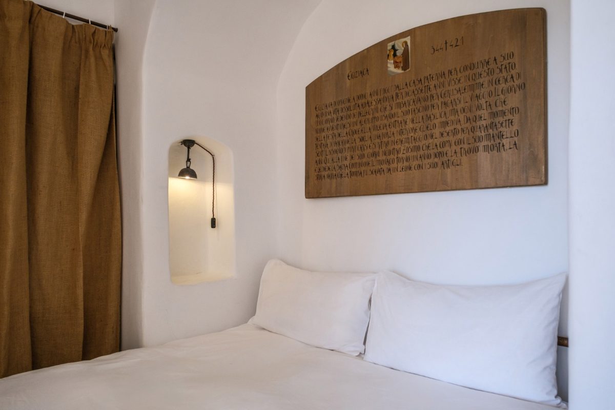 Celluzza Priore, white linen bed, jute curtain and painted panel devoted to Mary of Egypt