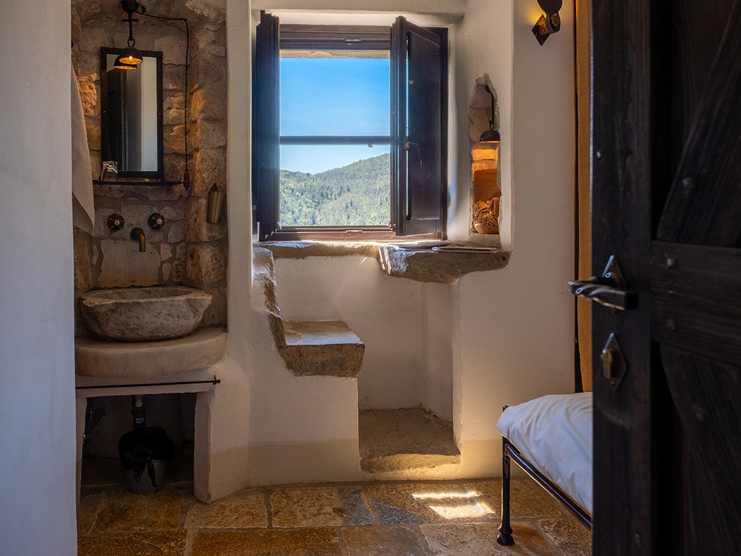 Celluzza Valley, stone basin and window open onto the wooded Umbrian valley